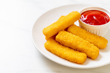 crispy fried fish fingers with breadcrumbs served on plate