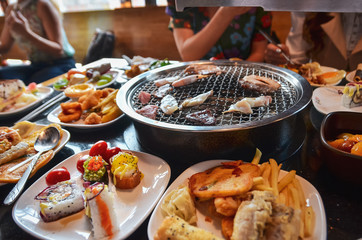 A variety of raw meat and sea products prepared on grill in asian restaurant. Selective focus.
