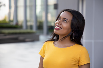 African woman looking up; portrait of happy confident black African woman looking up to blank space