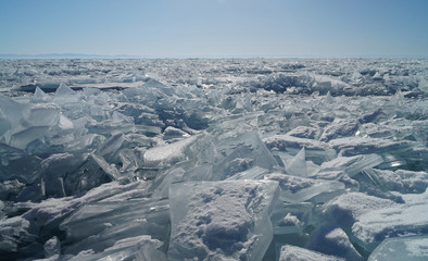 Fototapeta na wymiar Transparent, shiny ice hummocks are visible to the horizon