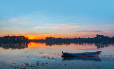 Euphrates (Fırat nehri) river in Birecik with blue boat at sunset - Birecik, Turkey