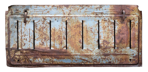 Crumpled rusty metal sheet that covers the diesel engine of a retro tractor isolated