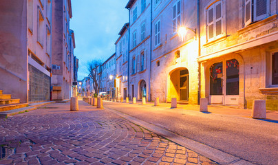 Fototapeta na wymiar Narrow street with typical orange houses at dusk - Avignon city, France 