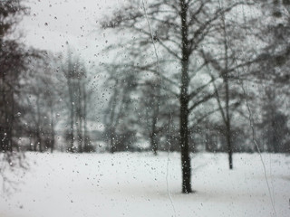 Raindrops on window with the picturesque winter landscape.