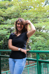 Young female wearing black t shirt and posing in the park. Suitable for mock up design template.