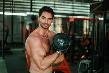 Handsome Man exercise in gym body-building with muscular strong body