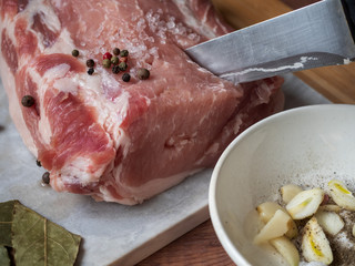 Raw pork and spices on a wooden table, preparation for baking at home