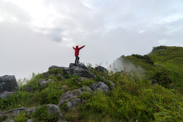Fototapeta premium View of a man stand on the top of the peak of Pha Tang in Chiang Rai, Thailand.