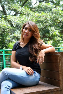 Young female wearing black t shirt and posing in the park. Suitable for mock up design template.