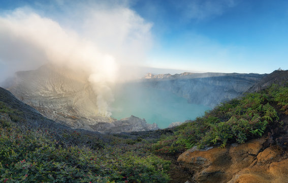 Beautiful panorama view of Kawah Ijen with green fern foreground at dawn in Java island, Indonesia.