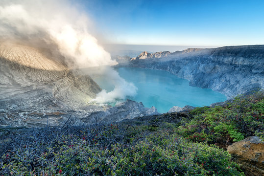 Beautiful panorama view of Kawah Ijen with green fern foreground at dawn in Java island, Indonesia.