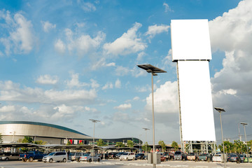 Blank big billboard blue sky background at parking lot,for your advertising,put your own text here,isolate white on board