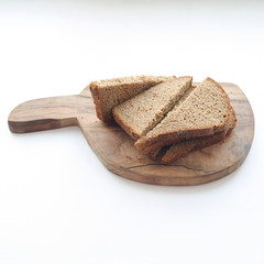 Black bread sliced with pieces on wooden board