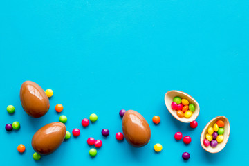 Fototapeta na wymiar Chocolate eggs - Easter symbol - frame on blue background top-down copy space