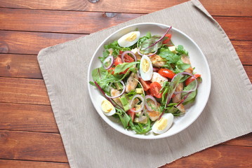 Chicken salad with avocado and cherry tomatoes, arugula and beet leaves. Healthy lunch bowl with vegetables and chicken on a wooden background. Healthy food concept