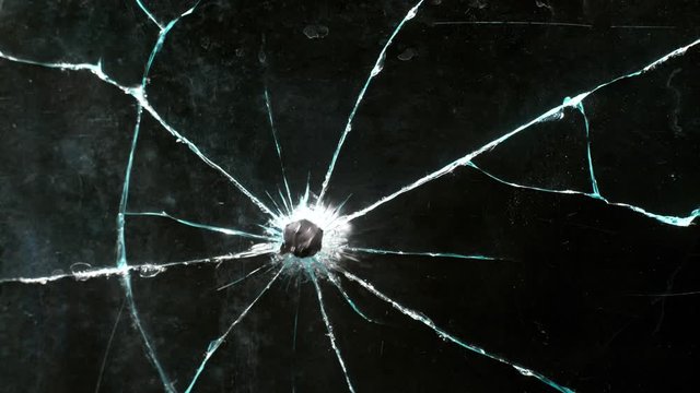 Glass breaking in slow motion on black background