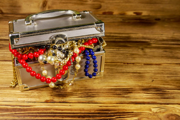 Jewelry box full of jewelry and accessories on wooden background