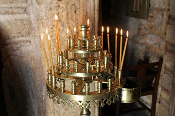 Lighting candles inside a Greek orthodox church.