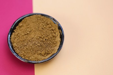 guarana powder in a black cup on a pink beige minimalist style.Super food. Useful product. Healthy eating concept. Natural energetic. Portion of Guarana Powder. copy space.