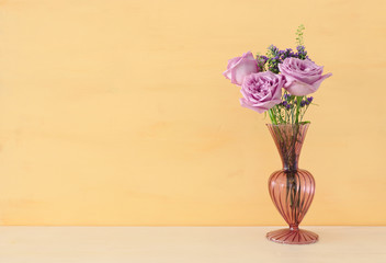 summer bouquet of pink roses flowers in the vase over wooden table