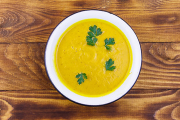 Pumpkin soup on a wooden table. Top view