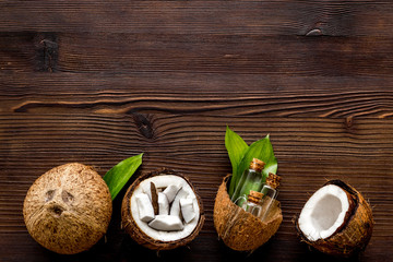 Cosmetic coconut oil for skin care on dark wooden background top-down frame copy space