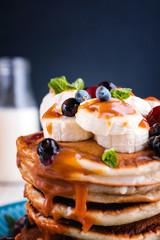 Delicious and lush pancakes with fresh fruits and berries, poured with salted caramel.