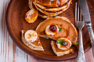 Delicious and lush pancakes with fresh fruits and berries, poured with salted caramel.