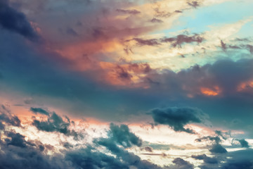 Obraz premium Beautiful dramatic clouds in the sky painted in vibrant juicy colors at sunset. Abstract bright cloudy background