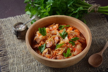 Cabbage stew with grilled sausage in tomato sauce - traditional dish of German, Polish or Russian cuisine