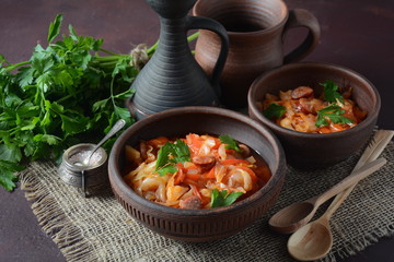 Cabbage stew with grilled sausage in tomato sauce - traditional dish of German, Polish or Russian cuisine