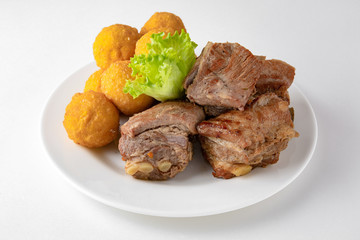 Baked pieces of pork with potato balls. Banquet festive dishes. Gourmet restaurant menu. White background.