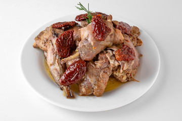 Braised rabbit with sun-dried tomatoes in sauce and herbs. Banquet festive dishes. Gourmet restaurant menu. White background.