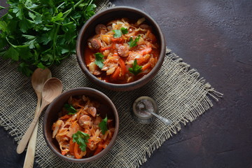 Cabbage stew with grilled sausage in tomato sauce - traditional dish of German, Polish or Russian cuisine