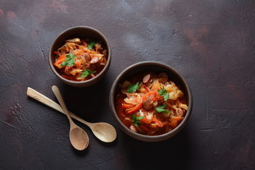 Cabbage stew with grilled sausage in tomato sauce - traditional dish of German, Polish or Russian cuisine