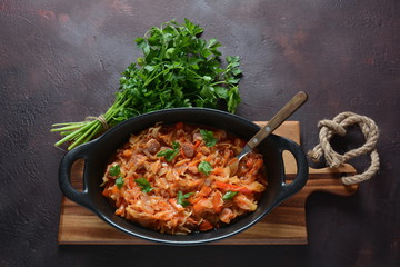 Cabbage stew with grilled sausage in tomato sauce - traditional dish of German, Polish or Russian cuisine