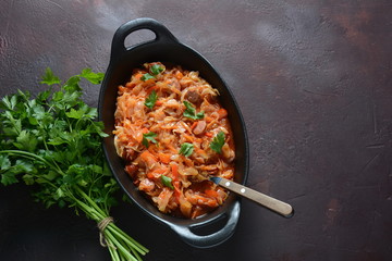 Cabbage stew with grilled sausage in tomato sauce - traditional dish of German, Polish or Russian cuisine