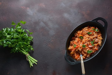 Cabbage stew with grilled sausage in tomato sauce - traditional dish of German, Polish or Russian cuisine