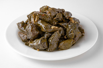 Fototapeta na wymiar Dolma. Cabbage rolls from cabbage, grape leaves and rice with meat. Stuffed peppers. Banquet festive dishes. Gourmet restaurant menu. White background.