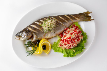 Baked fish, trout with vegetables. Banquet festive dishes. Gourmet restaurant menu. White background.