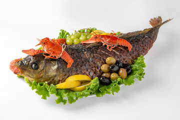 Baked fish stuffed with cereals and vegetables with seafood. Banquet festive dishes. Gourmet restaurant menu. White background.