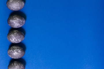 Eggs with marble stone effect painted with natural dye carcade flower on blue sparkling background