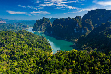 Fototapeta na wymiar Aerial drone shot of dense tropical rainforest and towering limestone cliffs with a central lake