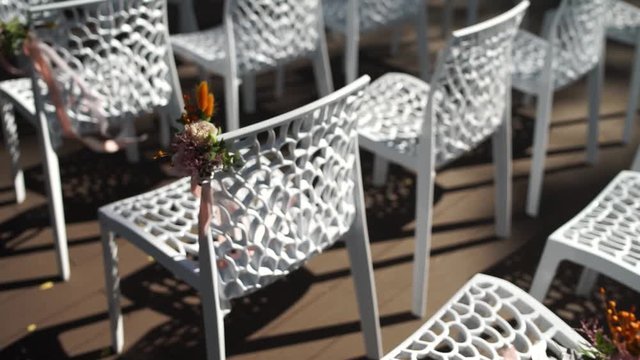white chairs for a wedding ceremony with decor
