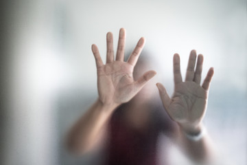 Blurry woman hand behind frosted glass metaphor panic and negative dark emotional
