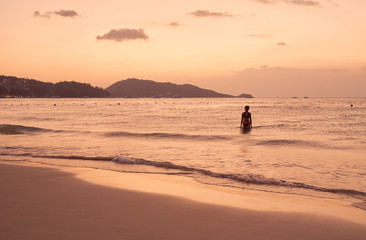 Panorama of Patong beach and Andaman sea on Phuket in Thailand during sunset. Pink and gold colors, view of the hills