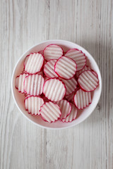 Radish Chips Slices in a white bowl on a white wooden background, top view. Flat lay, overhead, from above.