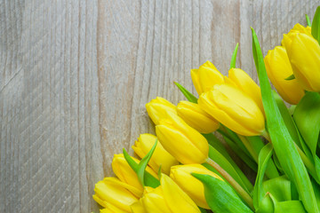 Beautiful yellow tulips on wooden background. Top view, copy space for text