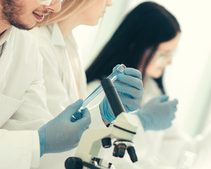 group of young biologists sitting at the laboratory table