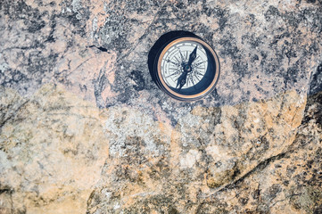 Fototapeta na wymiar The lonely compass on top of the rock